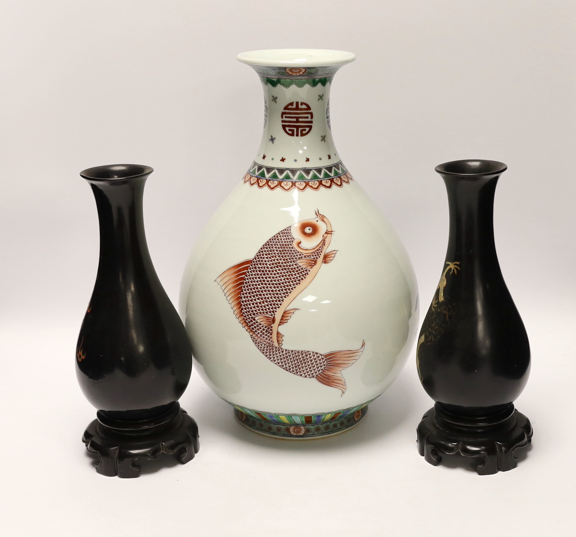 A Chinese porcelain ‘fish’ vase and a pair of Chinese lacquer vases on stands, tallest 33cm